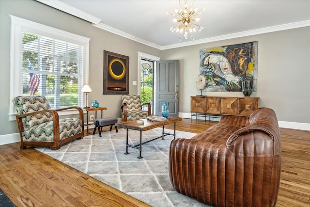 living area with a chandelier, baseboards, ornamental molding, and wood finished floors