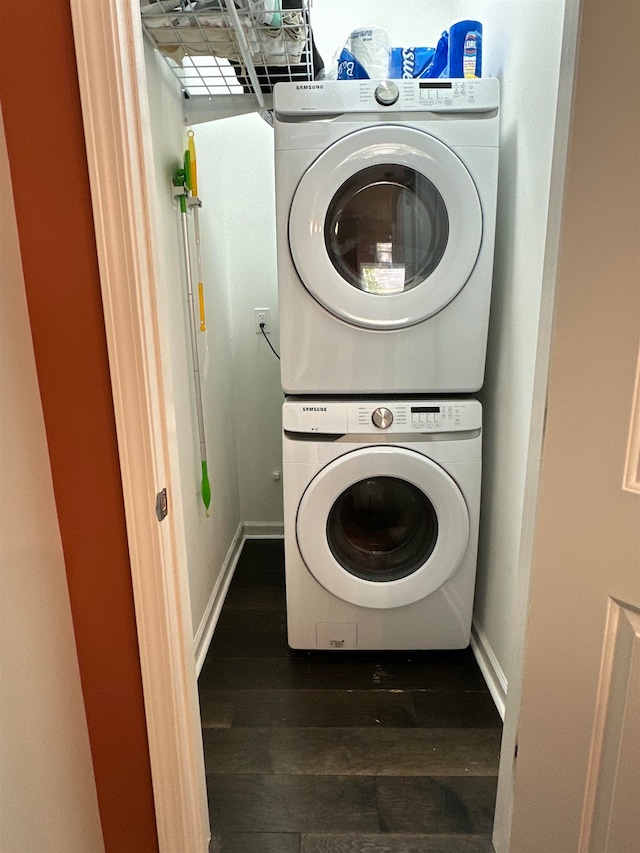 laundry area featuring stacked washer / drying machine and dark hardwood / wood-style flooring