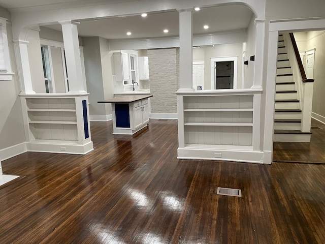 unfurnished living room with sink and dark wood-type flooring