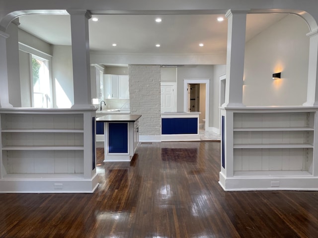 kitchen with dark hardwood / wood-style floors, ornamental molding, white cabinetry, and a center island