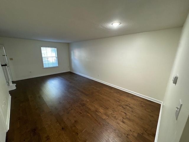 spare room with dark wood-type flooring