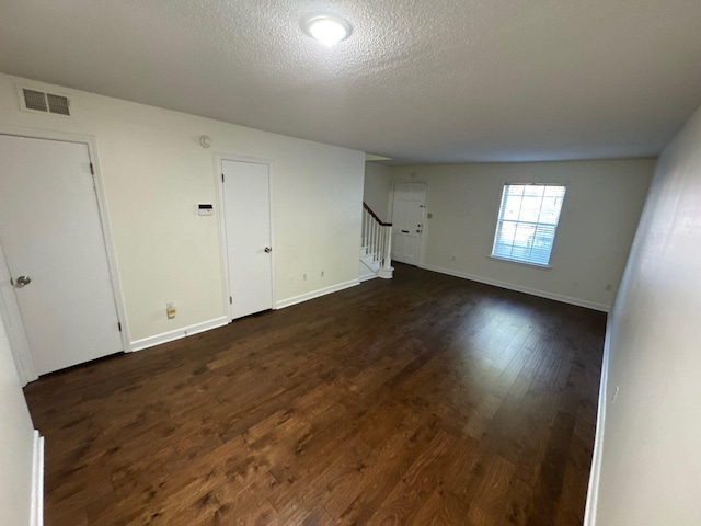 unfurnished room featuring a textured ceiling and dark hardwood / wood-style floors