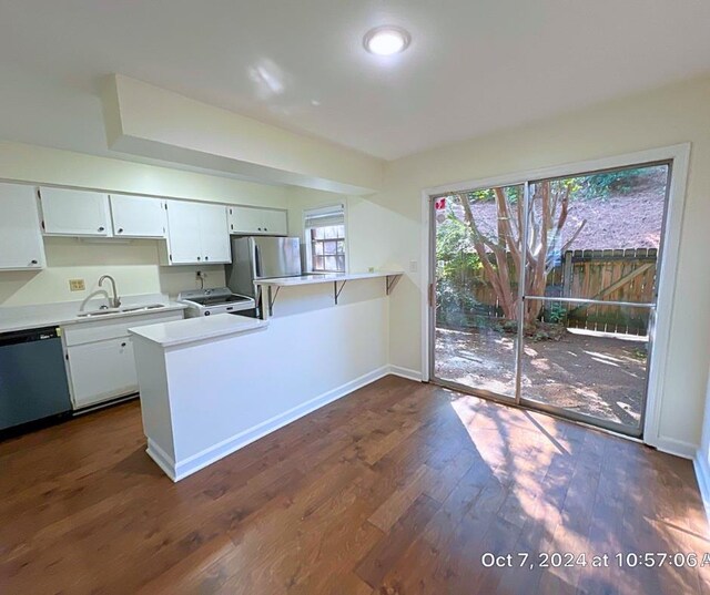 kitchen featuring white cabinets, kitchen peninsula, dark hardwood / wood-style flooring, stainless steel appliances, and sink