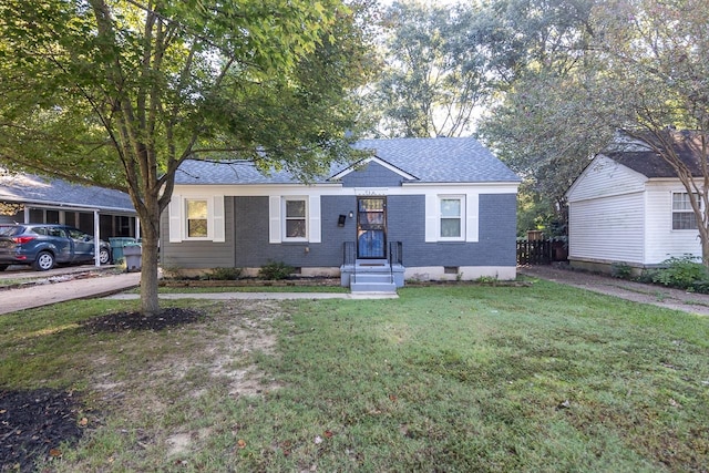 view of front of home with a front yard and a carport