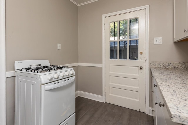 kitchen with light stone counters, white cabinets, ornamental molding, dark wood-type flooring, and white range with gas cooktop