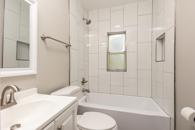 full bathroom featuring vanity, tiled shower / bath, and toilet