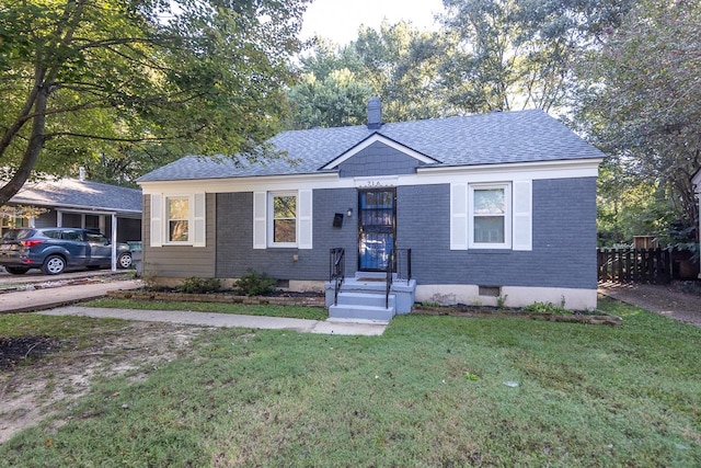 view of front of home with a carport and a front lawn