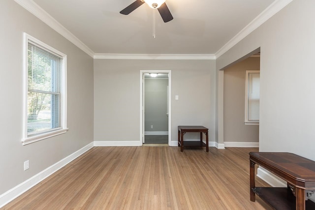 interior space with light wood-type flooring, ceiling fan, and crown molding