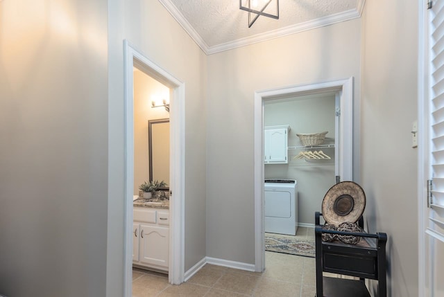 hallway featuring crown molding, washer / dryer, a textured ceiling, light tile patterned floors, and sink