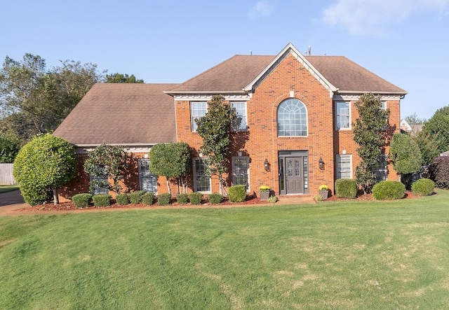 colonial home featuring a front lawn