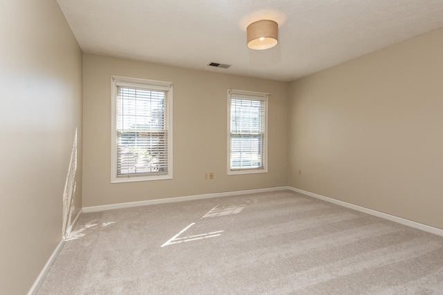 carpeted spare room featuring a textured ceiling