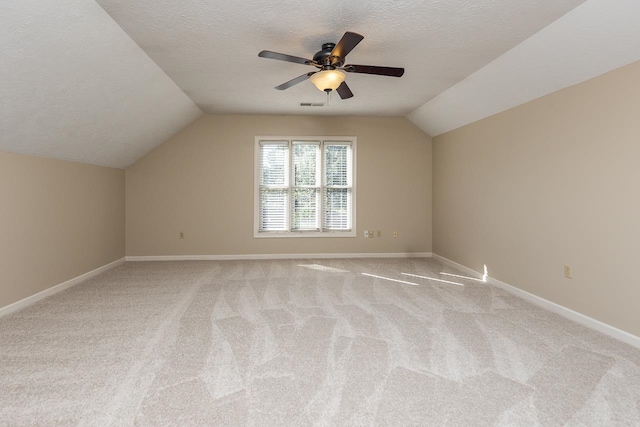 bonus room featuring light colored carpet, a textured ceiling, and vaulted ceiling