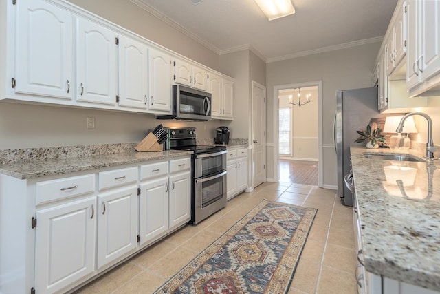 kitchen featuring light stone counters, sink, ornamental molding, white cabinetry, and appliances with stainless steel finishes