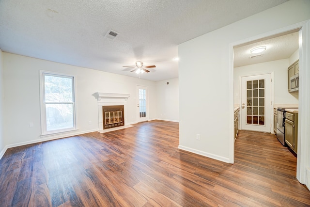 unfurnished living room with a textured ceiling, dark hardwood / wood-style flooring, and ceiling fan