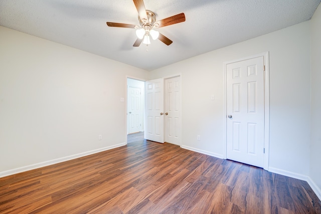 unfurnished bedroom with a textured ceiling, dark hardwood / wood-style flooring, and ceiling fan