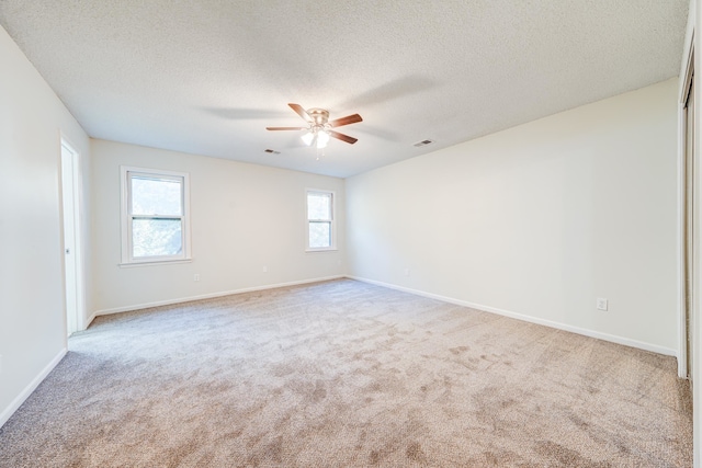 carpeted empty room with a textured ceiling and ceiling fan