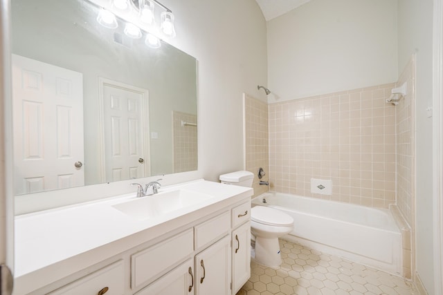 full bathroom with tile patterned flooring, tiled shower / bath combo, vanity, and toilet