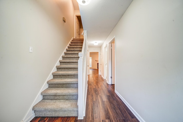 stairs with hardwood / wood-style flooring and a textured ceiling