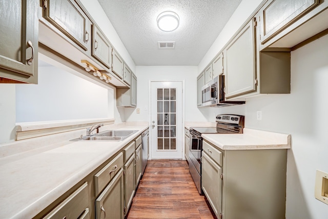 kitchen featuring a textured ceiling, stainless steel appliances, sink, and dark hardwood / wood-style flooring