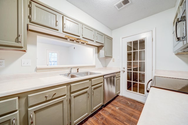 kitchen featuring a textured ceiling, sink, dark wood-type flooring, and stainless steel appliances