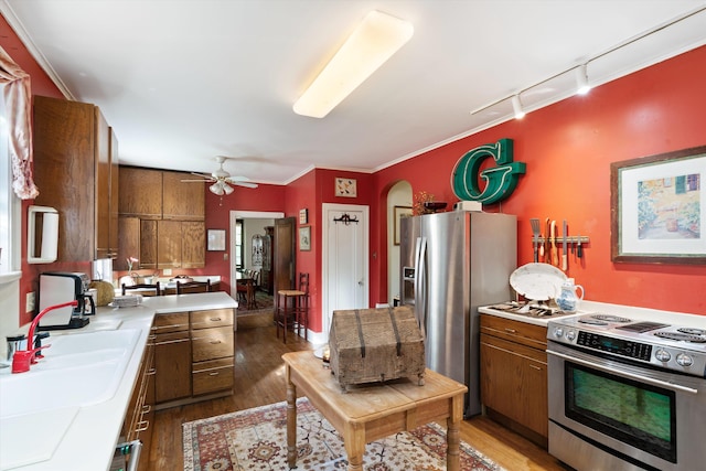 kitchen with dark hardwood / wood-style floors, ceiling fan, rail lighting, and stainless steel appliances