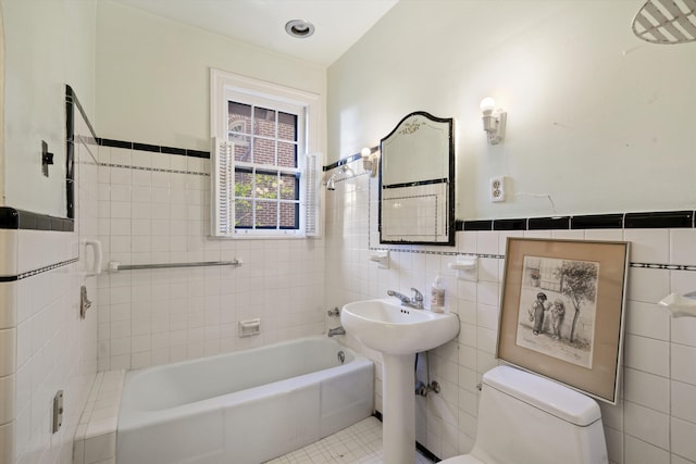 bathroom featuring a bathtub, tile patterned flooring, toilet, and tile walls