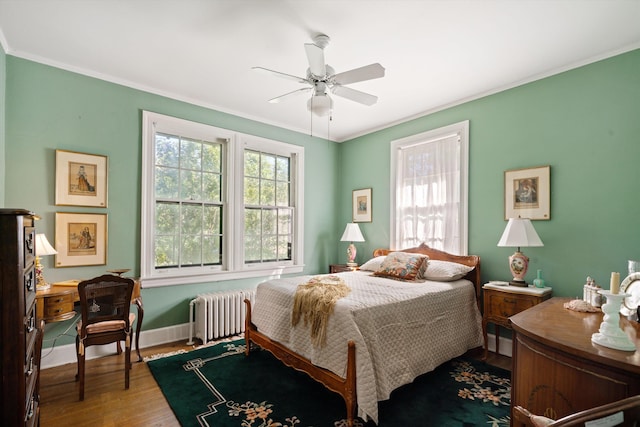 bedroom with ceiling fan, hardwood / wood-style flooring, ornamental molding, and radiator