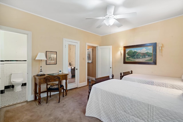 carpeted bedroom with ensuite bathroom and ceiling fan