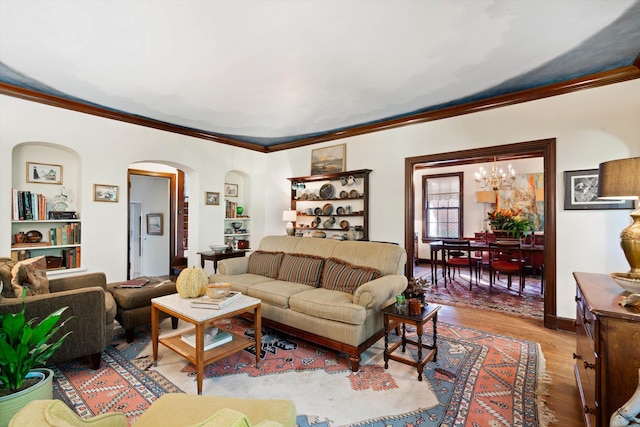 living room featuring ornamental molding, a chandelier, and light hardwood / wood-style floors