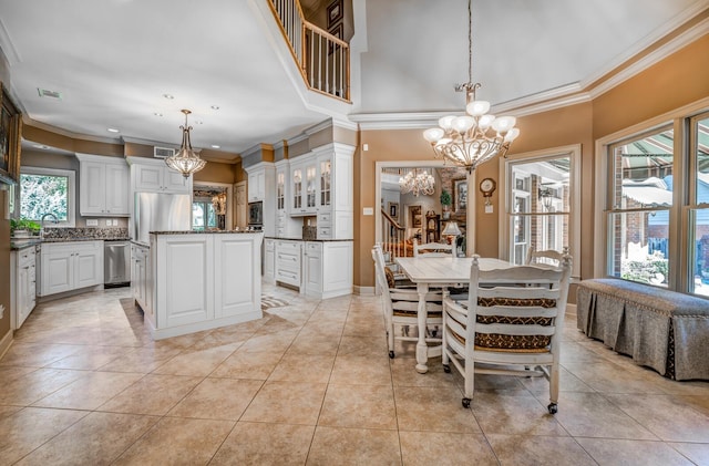 dining area featuring ornamental molding, an inviting chandelier, light tile patterned floors, and a wealth of natural light