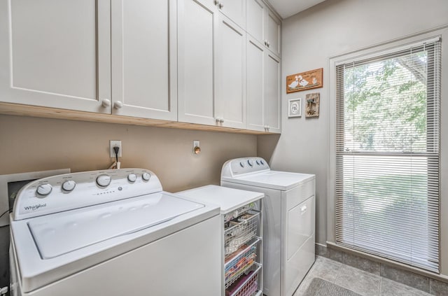 clothes washing area with cabinets and washing machine and clothes dryer