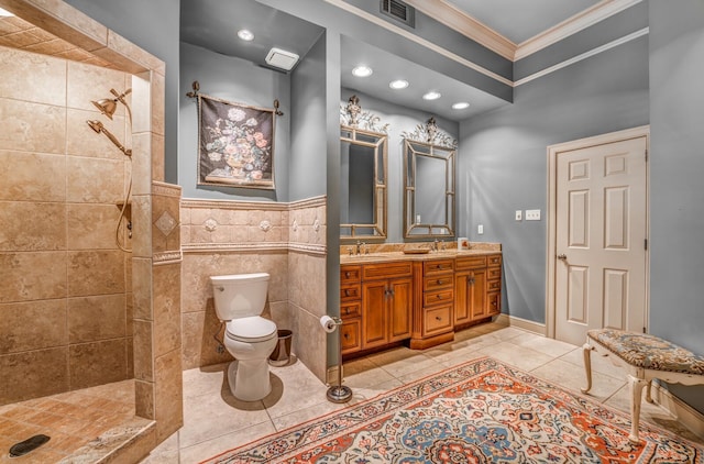 bathroom with a tile shower, tile patterned flooring, crown molding, vanity, and toilet