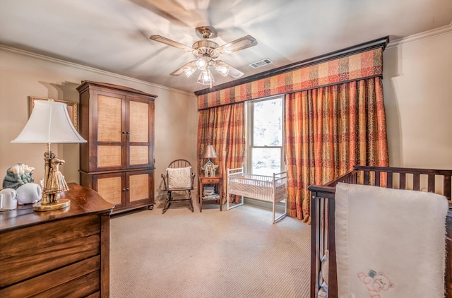 carpeted bedroom with ornamental molding, ceiling fan, and a nursery area