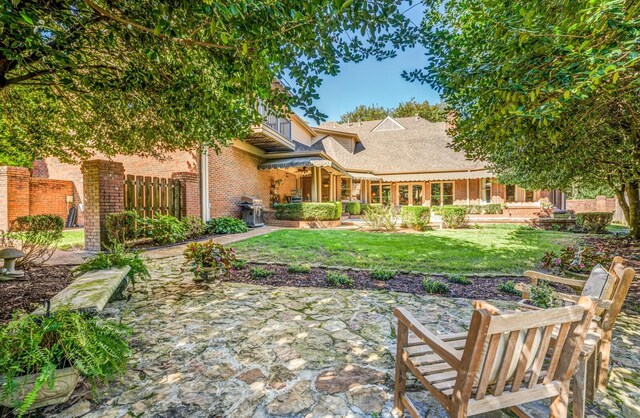 rear view of house featuring a yard and a patio area