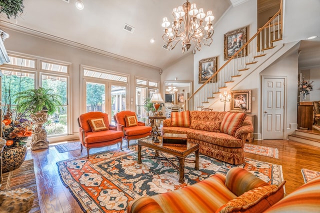 living room featuring hardwood / wood-style flooring, crown molding, a chandelier, and high vaulted ceiling