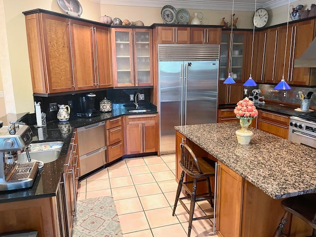 kitchen featuring a kitchen breakfast bar, decorative backsplash, built in refrigerator, crown molding, and sink