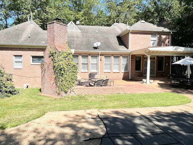 rear view of house with a lawn and a patio area