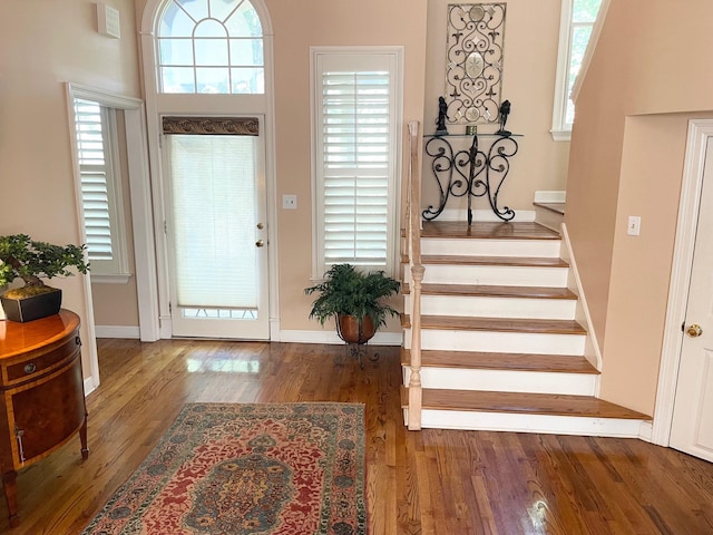 entrance foyer with a high ceiling, plenty of natural light, and hardwood / wood-style floors