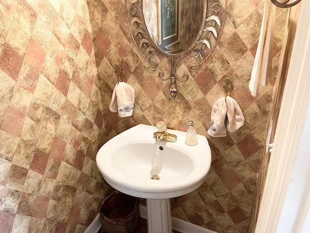 bathroom featuring tile walls and sink