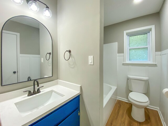 bathroom with wood-type flooring, vanity, and toilet