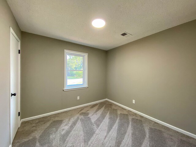 carpeted spare room featuring a textured ceiling