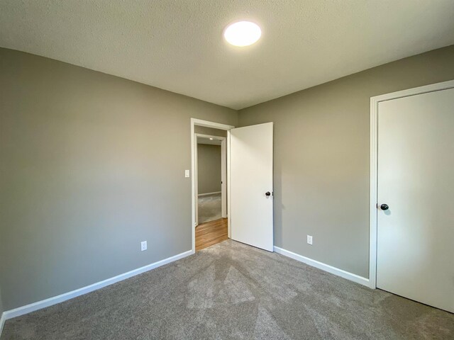 unfurnished bedroom featuring a textured ceiling and carpet flooring