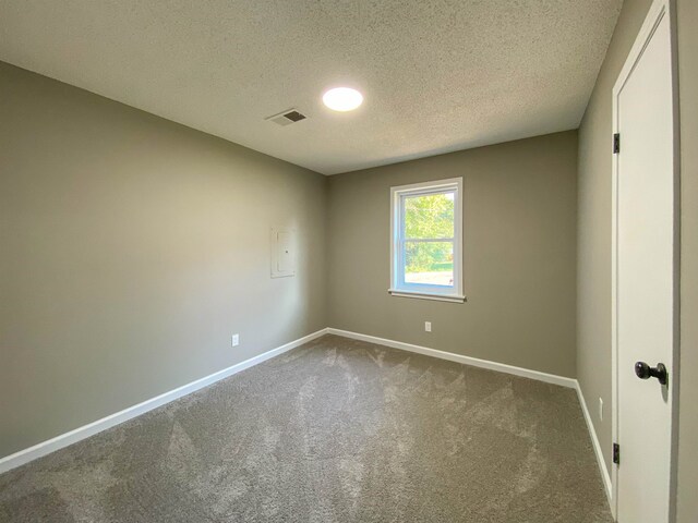 carpeted empty room with a textured ceiling