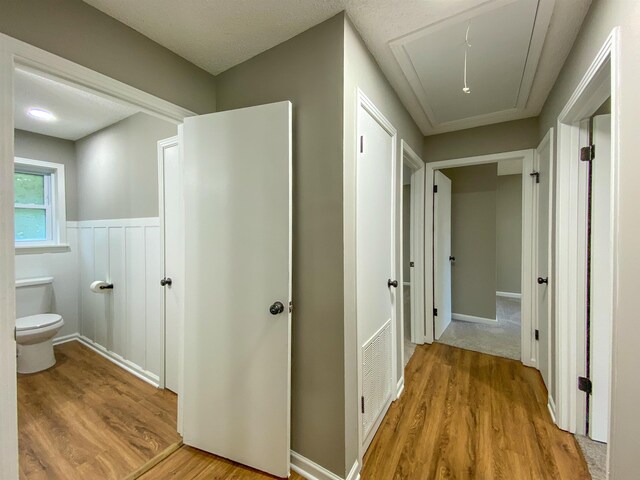 corridor featuring light hardwood / wood-style floors and a textured ceiling