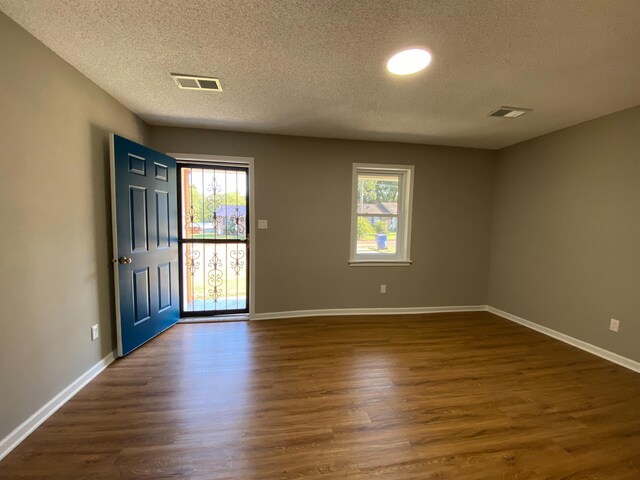 spare room with dark hardwood / wood-style flooring and a textured ceiling