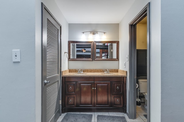 bathroom with tile patterned flooring, vanity, and toilet