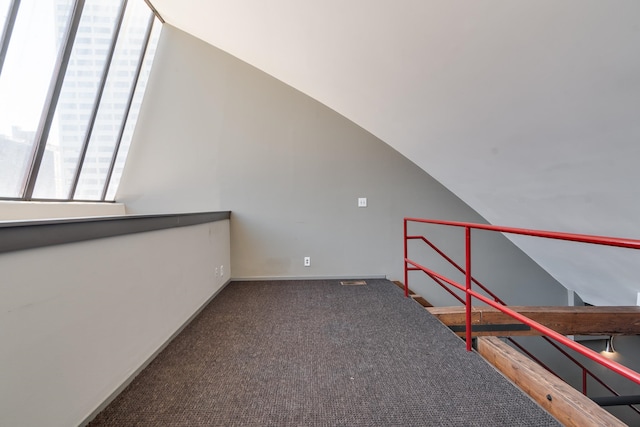 additional living space featuring lofted ceiling and carpet