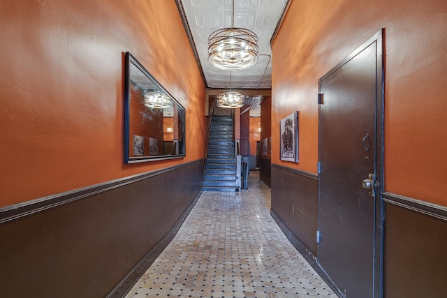 hall featuring crown molding and a notable chandelier