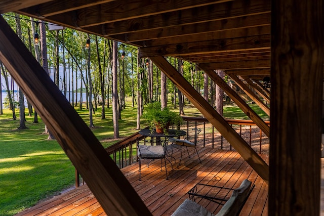 wooden terrace with a water view and a lawn