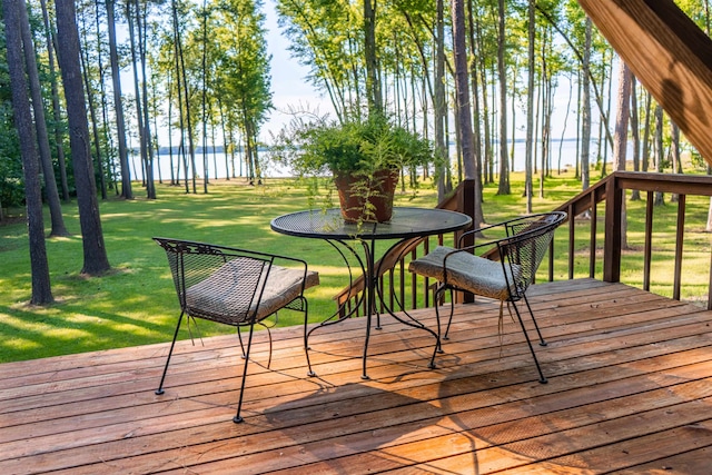 wooden terrace with a water view and a yard